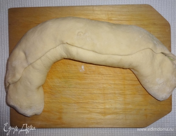 Скатать тесто с луком в рулет.