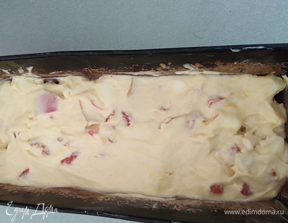 Форму для выпечки «кирпичик» смазать маслом и выложить в нее тесто. Разровнять.