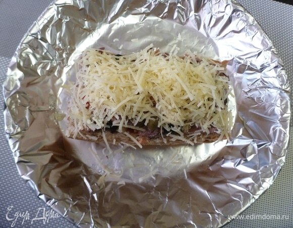 Твердый сыр натереть на терке и посыпать будущую ленивую пиццу. Заранее разогреть духовку до 200°C. Поставить ленивую пиццу в духовку на минут 20.