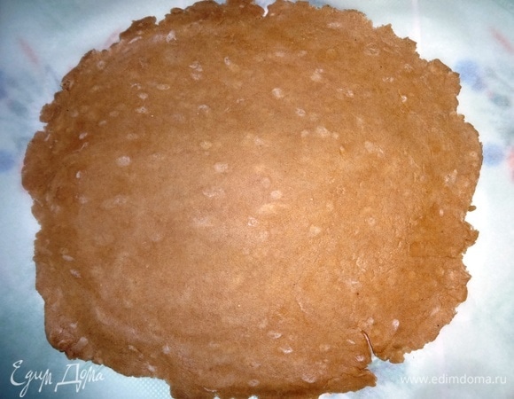 Стол застелить пергаментом и раскатать тесто в круглый тонкий пласт. Положить бумагу с тестом на противень.