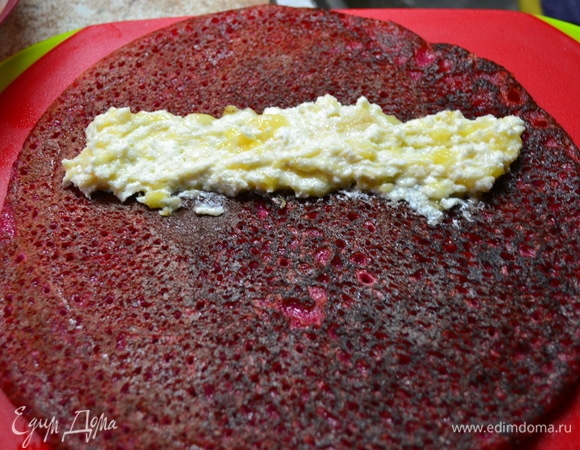 Начинку выложить на блин с подрумяненной стороны. Свернуть в рулет, разделить ножом на две части.