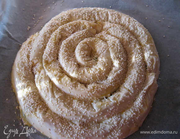 На один рулетик можно использовать два листа фило, один на другой. Так повторяем несколько раз, стараясь равномерно рассчитать количество начинки и теста. Смазываем яйцом и посыпаем кунжутом.