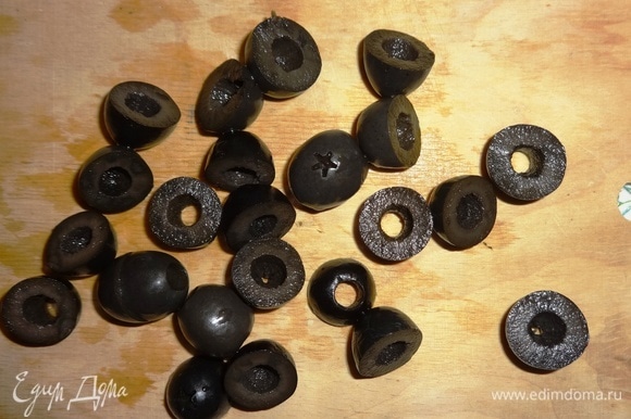 Оливки процедить от жидкости. Часть оливок нарезать кольцами, из остальных вырезать фигурки-крабики.