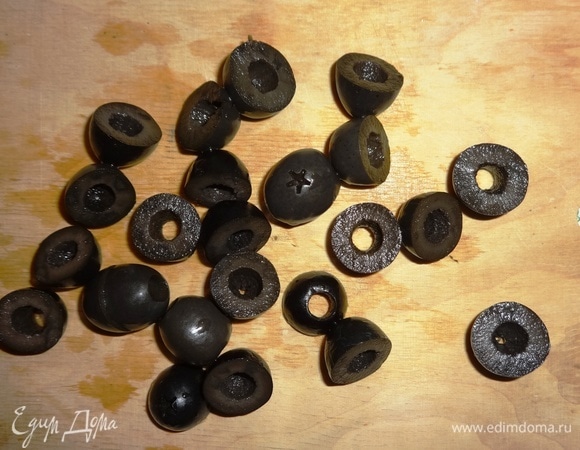 Оливки процедить от жидкости. Часть оливок нарезать кольцами, из остальных вырезать фигурки-крабики.