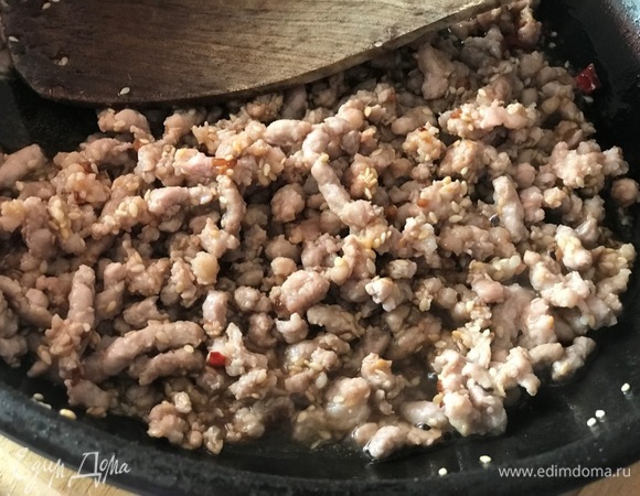 Разогреть растительное масло на сковороде и обжарить фарш с чесноком.