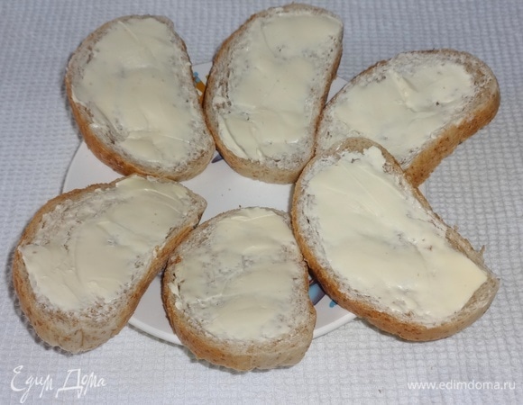 Кусочки батона намазать тонким слоем сливочного масла.