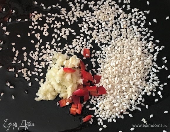 В большой сковороде вок разогреть кунжутное масло, соевый соус, положить в него измельченный перец чили без семян, натертый на мелкой терке имбирь и кунжутное семя.