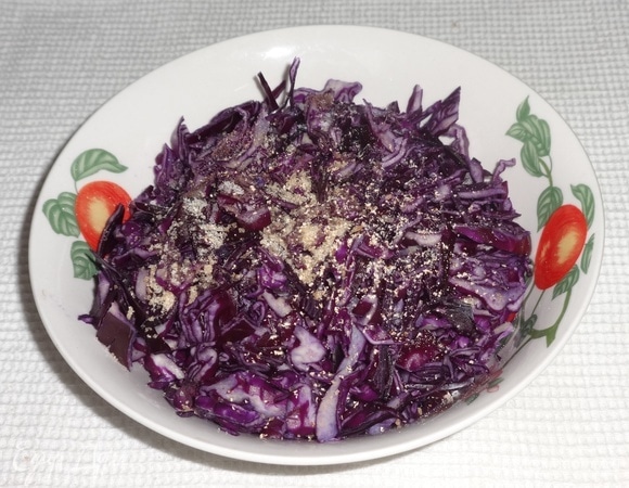 Положить капусту в миску, добавить сахар, соль, мускатный орех, перемешать. Помять капусту руками до появления сока.