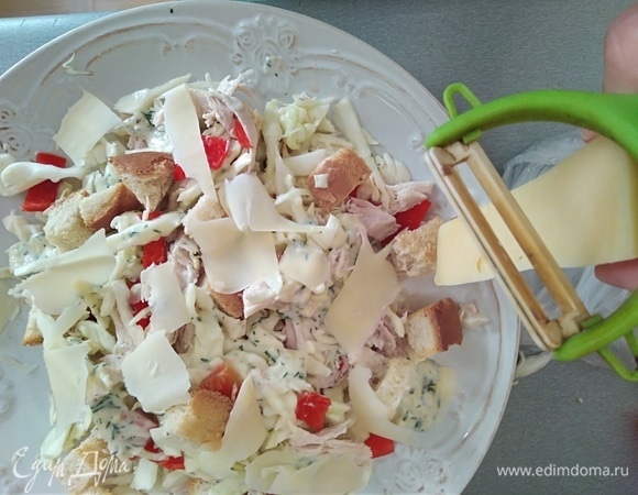 Заправить салат. Сверху разложить сухарики и тертый сыр.