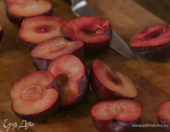 Сливы разрезать пополам и удалить косточки.