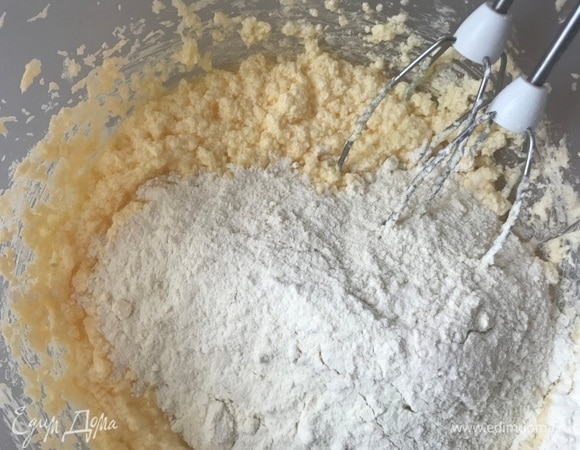 Добавить муку с разрыхлителем и ванильный экстракт. Влить 5 ст. л. воды и еще раз перемешать.