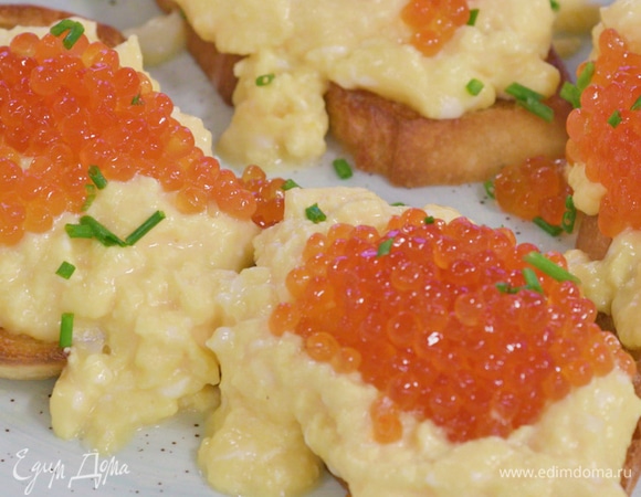 На тосты выложить взбитый омлет и икру, посыпать зеленым луком.