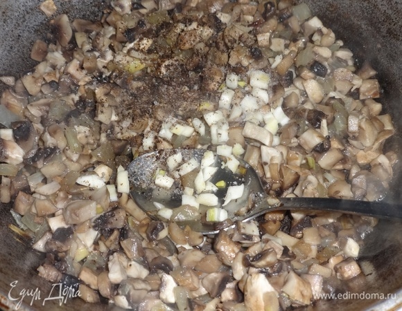Чеснок мелко нарезать, добавить к грибам, поперчить.