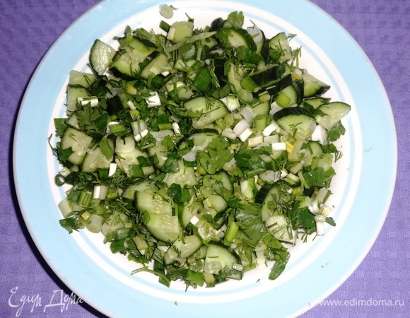 Нарезанные огурцы и зелень сложить в салатник, перемешать.
