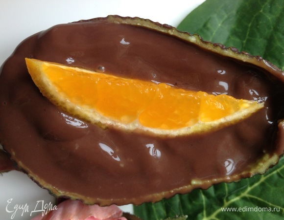 Наполнить шоколадной начинкой «блюдца из авокадо». Сверху выложить мандариновую дольку.