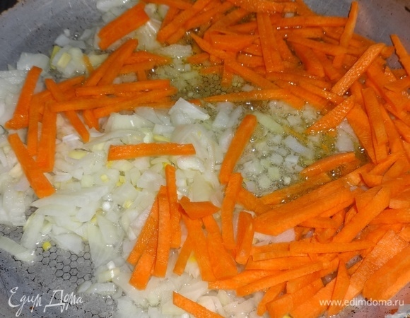 В сковороде разогреть 3 ст. л. растительного масла, положить лук и морковь и обжаривать до румяности.