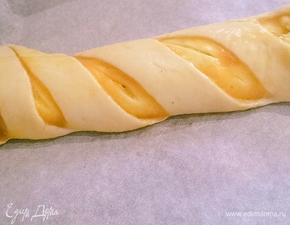 У меня осталось немного теста. Нашла в холодильнике джем (может быть любой или даже варенье, у меня абрикосовый джем). Раскатываем тесто в пласт, обильно смазываем джемом и сворачиваем швом вниз. Делаем разрезы, смазываем яйцом и отправляем в печь минут на 10–15 при температуре 150–180°C, смотрите сами.