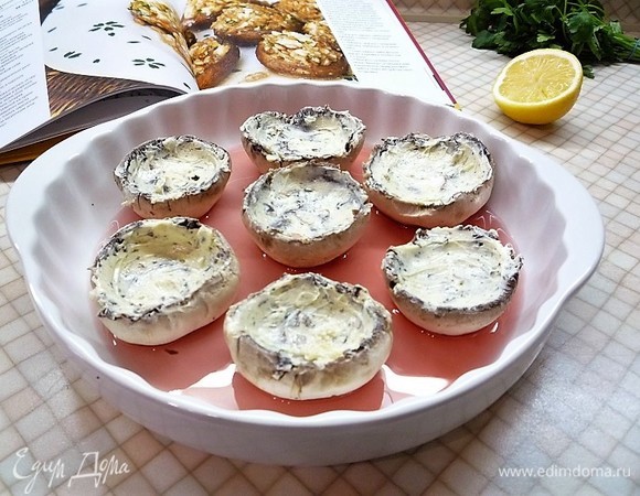 Внутреннюю сторону шляпок грибов смазываем пряным маслом, выкладываем в форму для запекания, вливаем оставшееся вино, накрываем форму фольгой и запекаем в заранее разогретой духовке при температуре 180°C 25–30 минут.