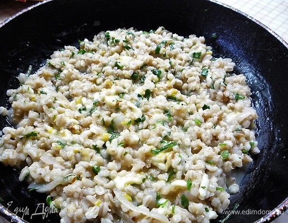 Выкладываем петрушку, цедру лимона и сулугуни в сковороду к перловке, перемешиваем и начиняем получившейся массой шляпки грибов.