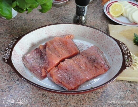 Рыбу уложить в форму для запекания кожей вниз, посолить, поперчить, полить соком половины лимона.