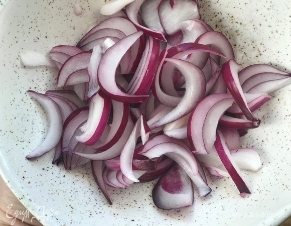 Красный лук нарезать полосками, сбрызнуть винным уксусом и оставить на 7–10 минут.