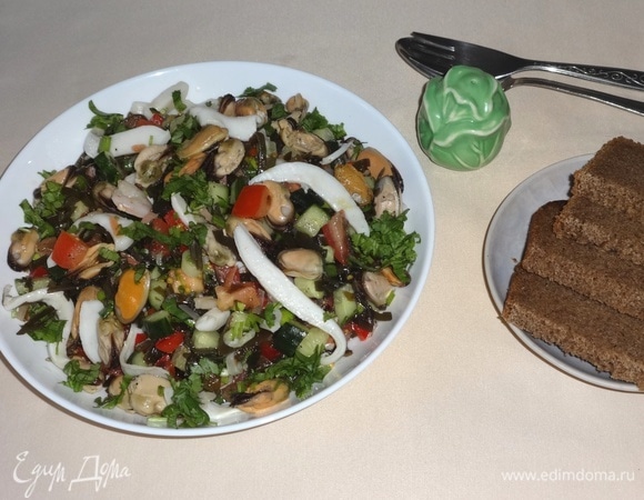 Выложить смесь овощей и морской капусты в салатник, сверху выложить морской коктейль. Полить салат 2 ст. л. масла из банки. Посыпать мелко нарезанной кинзой. Подать салат к столу. Приятного аппетита!