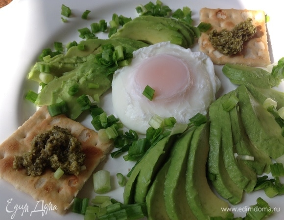 На тарелку положить яйцо пашот, по краям выложить авокадо, лук. Соус песто можно положить на гренку, хлеб или крекер. Посолить. По желанию можно полить оливковым маслом.