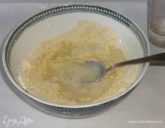 В масляно-мучную крошку влить порциями воду и замесить тесто.