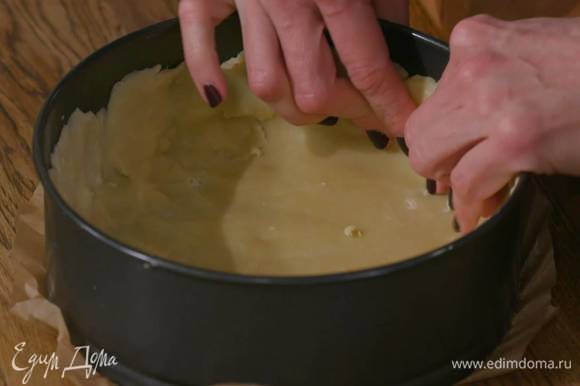 Дно разъемной формы для выпечки выстелить пищевой бумагой, выложить тесто и сформировать тонкий корж с бортиками (оставшееся тесто можно заморозить).