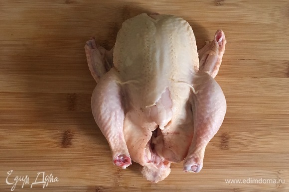 Цыпленка тщательно промыть и просушить. Он должен быть очень сухой, только тогда получится хрустящая корочка. Острым ножом сделать 8–10 надрезов на ногах, на крылышках и грудке цыпленка.