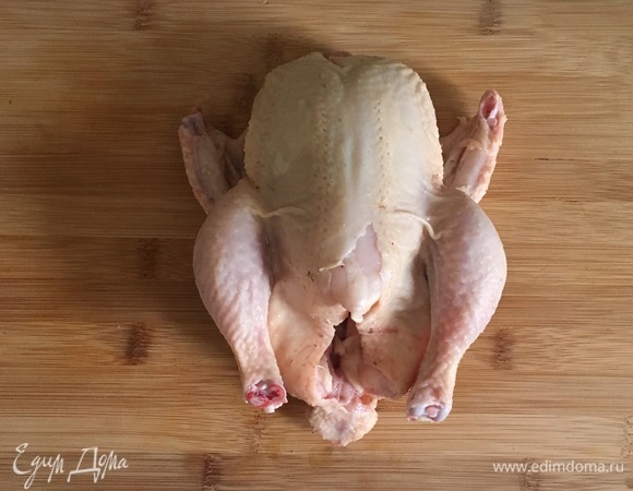 Цыпленка тщательно промыть и просушить. Он должен быть очень сухой, только тогда получится хрустящая корочка. Острым ножом сделать 8–10 надрезов на ногах, на крылышках и грудке цыпленка.