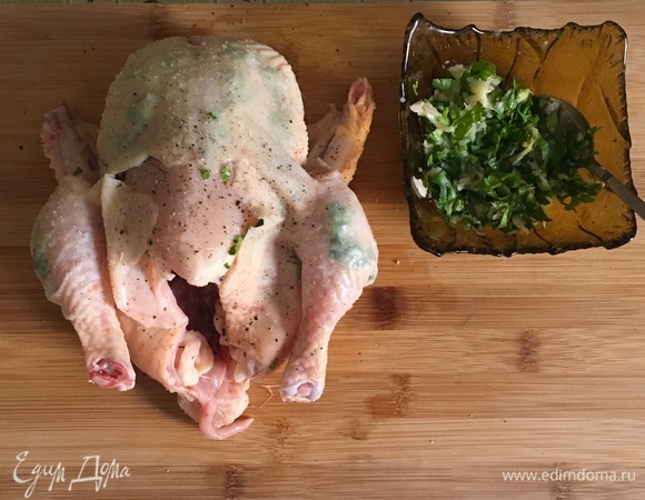 Смешать чеснок и петрушку. Половиной этой смеси заполнить надрезы на коже цыпленка. Тщательно посолить и поперчить цыпленка снаружи и внутри.