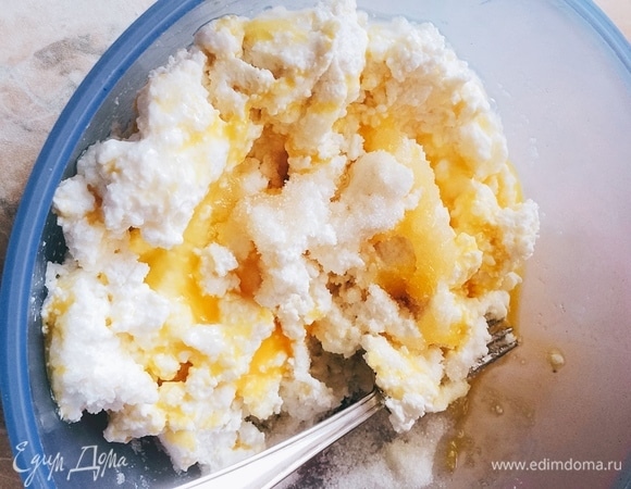 В миску выложить творог, яйцо, соль, сахар, ванилин. Хорошо перемешать вилкой (до более или менее однородной массы). Всыпать буквально 2 столовые ложки муки (остальная мука нужна для панировки) и разрыхлитель. Все тщательно перемешать.