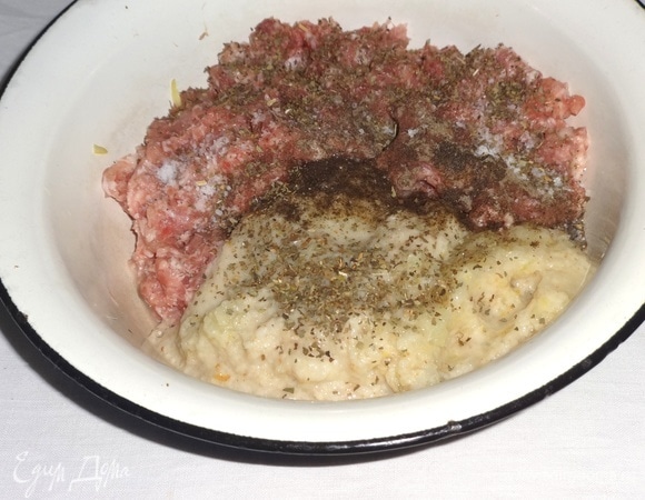 Батон замочить в воде, затем отжать. Лук почистить, нарезать кусочками. Чеснок почистить. Лук, чеснок и хлеб измельчить в блендере или мясорубке. Добавить к фаршу, посолить, поперчить, добавить приправы, перемешать.