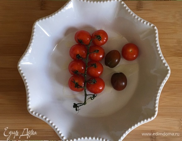 Духовку предварительно разогреть до 190°C. Ветку с помидорами выложить в глубокий противень, посолить, поперчить, сбрызнуть 1 ст. л. оливкового масла и отправить в разогретую духовку на 15–20 минут.