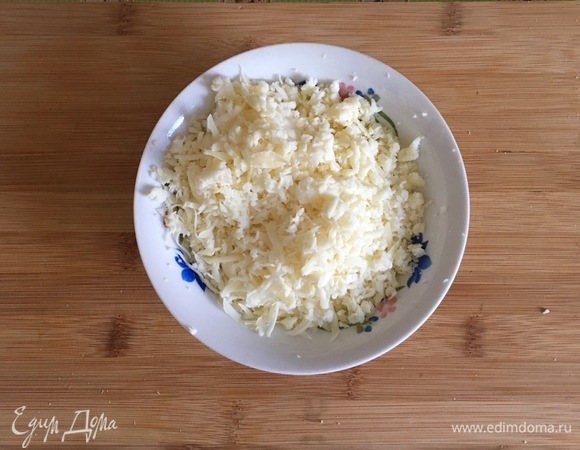 Пармезан и моцареллу натереть на крупной терке, добавить чеснок, измельченный базилик, яйцо и 1 ст. л. муки, все перемешать.