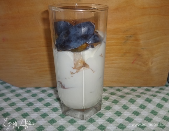 На крем выложить часть слив, сверху — опять слой крема. Аналогичным образом наполнить 2 других стакана. Шоколадное печенье измельчить в крошку и украсить десерт.