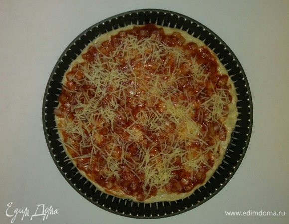 Посыпаем сыром всю поверхность смазанного соусом теста.