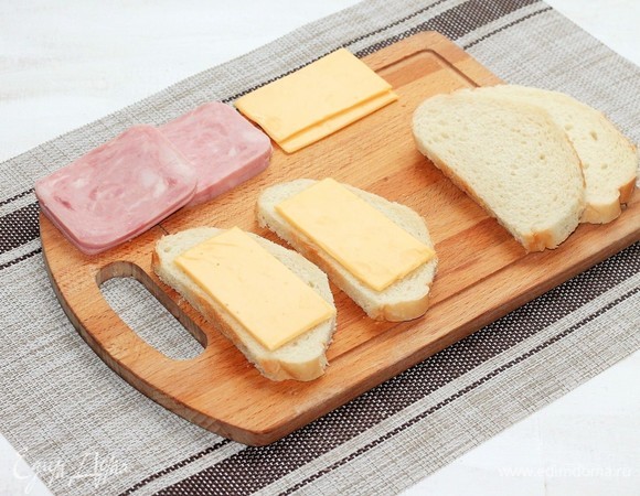 На 2 кусочка хлеба выложить по ломтику сыра.