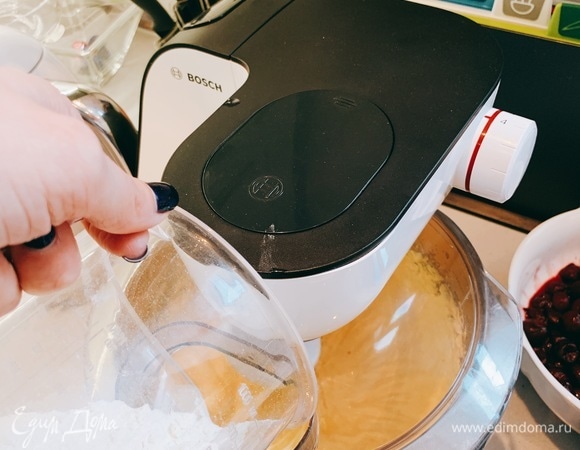 Затем всыпаем половину предварительно просеянной муки.