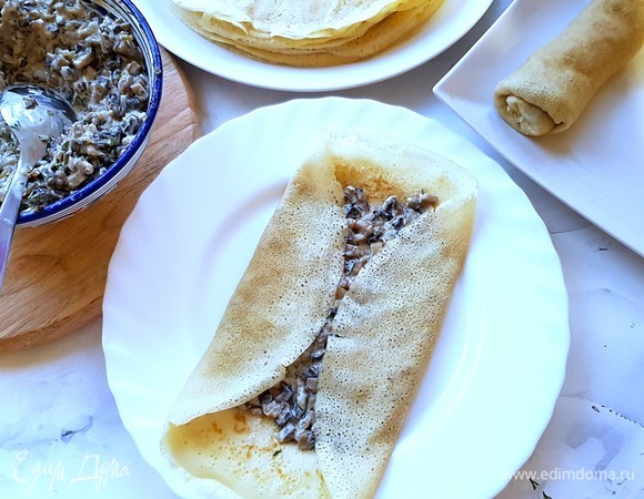 Затем начиняем блины начинкой. Выкладываем жюльен на середину блина, загибаем бока внутрь.