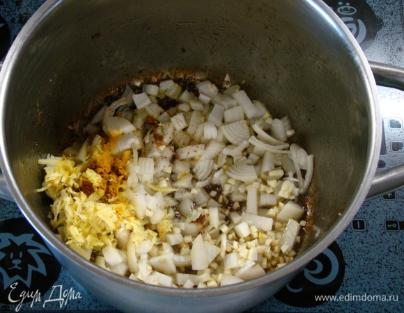В кастрюлю, где обжаривалась баранина, всыпать лук, чеснок, тертый имбирь и карри. Все перемешать и обжарить.