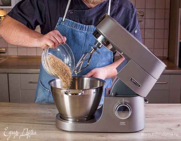 Постепенно введите смесь муки с орехами, постоянно перемешивая тесто с помощью насадки для смешивания.