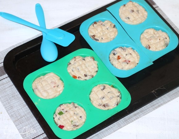 Смазываем формочки для выпечки растительным маслом и равномерно раскладываем тесто. Удобнее раскладывать силиконовой лопаткой или силиконовой ложкой. Если простая ложка, то при раскладке теста макаем ее в воду.