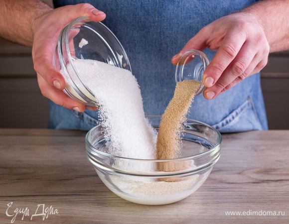 Приготовьте опару. Для этого в емкости смешайте теплое молоко, 0,5 ст. сахара и дрожжи.