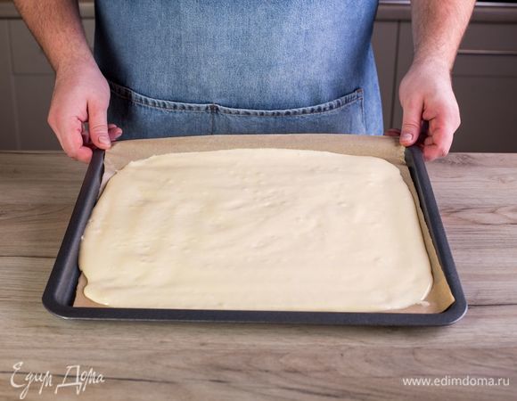 На противень выложите пергаментную бумагу. Выложите тесто на противень и разровняйте. Поставьте противень на верхнюю полку духовки и выпекайте в течение 4–5 минут.