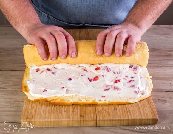 Аккуратно сверните рулет и положите его швом вниз. Оберните пищевой пленкой и отправьте в холодильник на 1–2 часа.