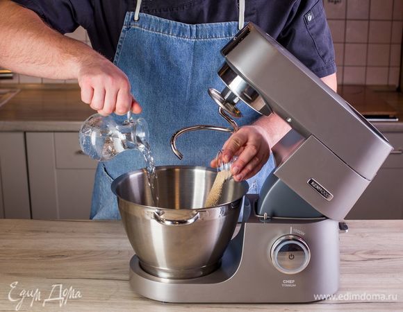 Разогрейте духовку до 250°С. В чашу кухонной машины KENWOOD влейте теплую воду, всыпьте дрожжи и дайте им раствориться.