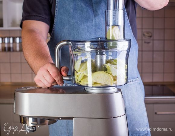 Баклажаны помойте и очистите от кожуры. Установите на кухонную машину KENWOOD насадку кухонный комбайн и с ее помощью нарежьте баклажаны кружочками.