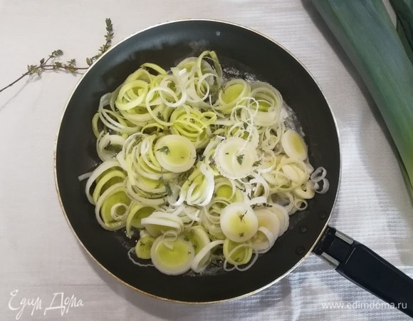 В сковороде разогреть по 1 ст. л. оливкового и сливочного масел. Выложить нарезанный тонкими кольцами порей, листья тимьяна.